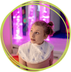 Girl in sensory room with pink lights